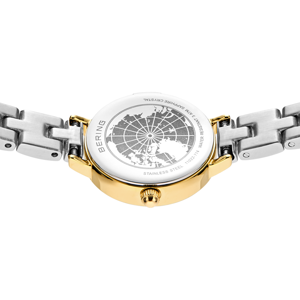 Engraved watch case back with the silver- and gold-tone link bracelet extended to either side.