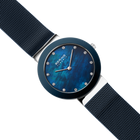 Diagonal overhead view of the mottled blue dial, silver-tone with blue bezel case and blue mesh strap.