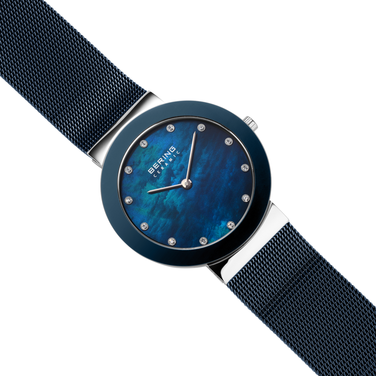 Diagonal overhead view of the mottled blue dial, silver-tone with blue bezel case and blue mesh strap.