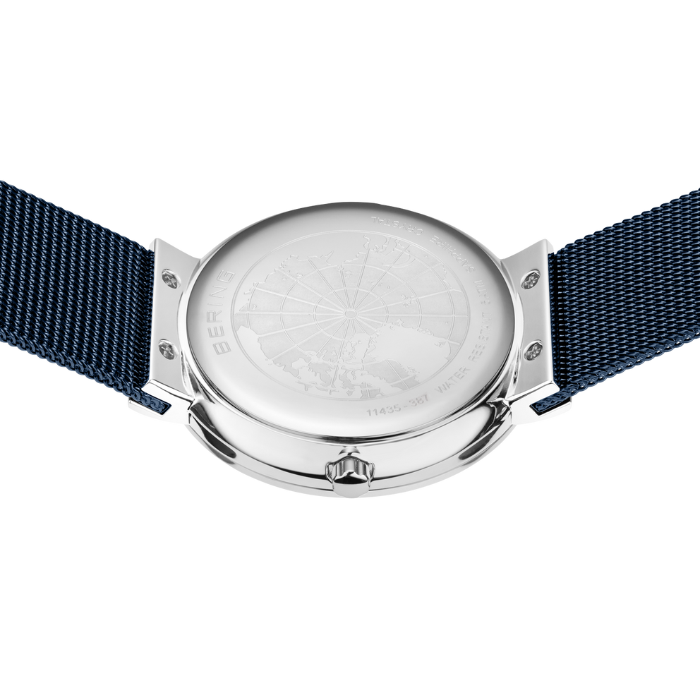 Engraved watch case back with the blue mesh strap extended to either side.
