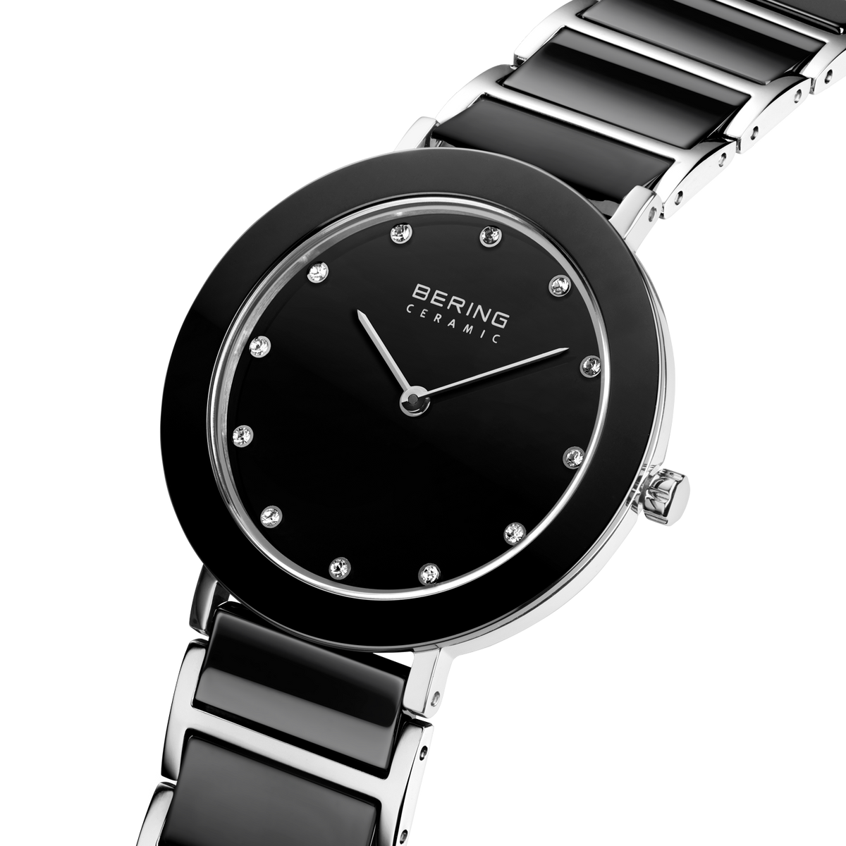 Angled close-up of the black dial with bright dot markers and silver-tone with black bezel case beside the black-centered silver-tone link bracelet.