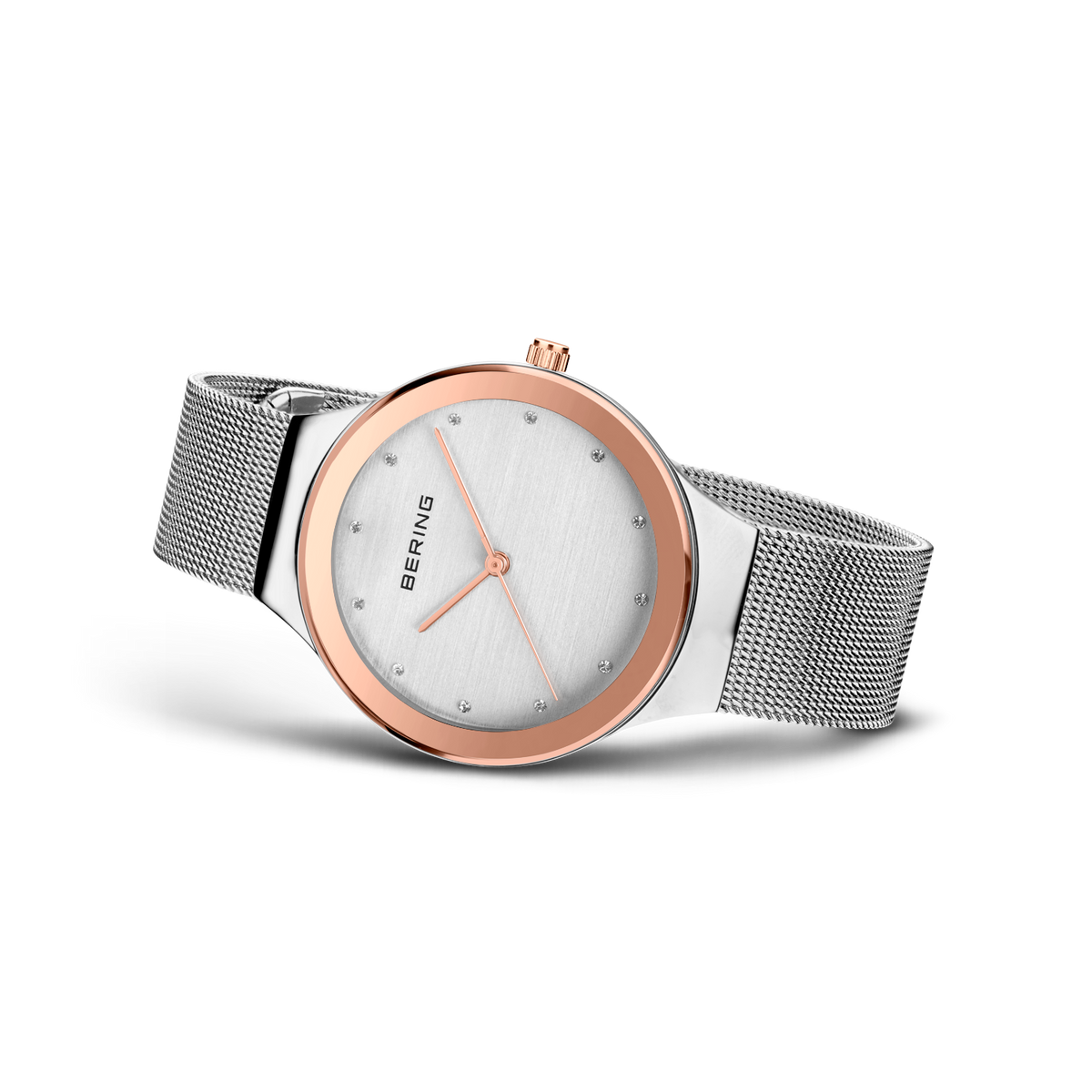 Angled watch view: pale dial with bright dot markers and silver-tone mesh strap extended.