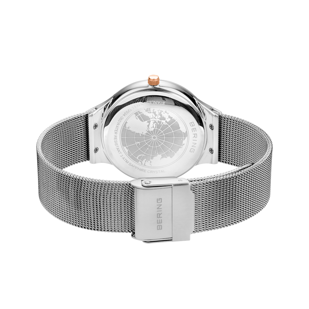 Rear view of the watch with its silver-tone mesh strap looped and fastener closed.