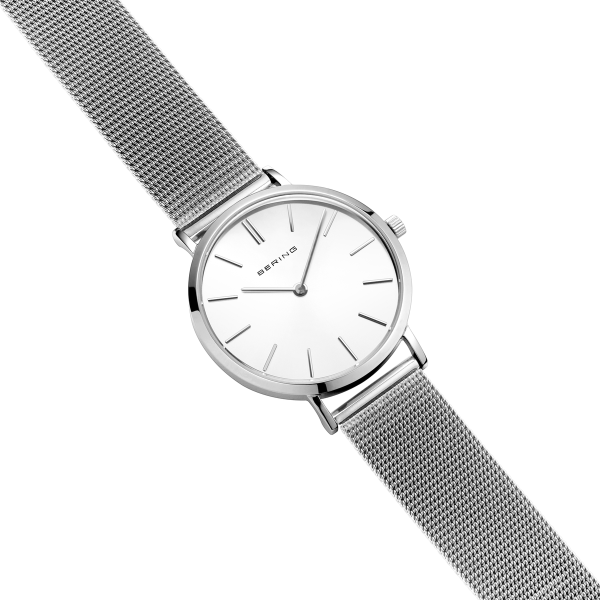 Diagonal overhead view of the white dial, silver-tone case and silver-tone mesh strap.
