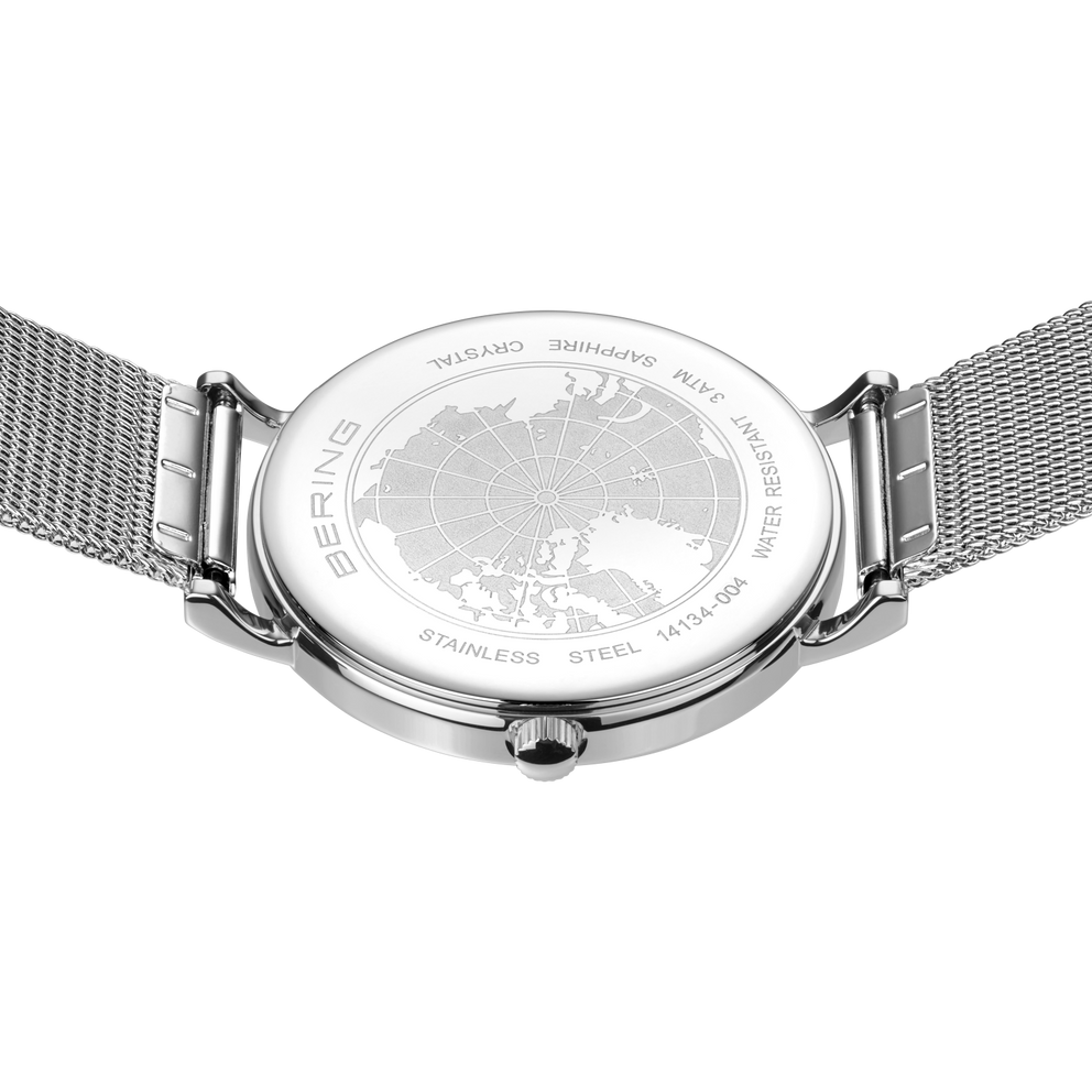 Engraved watch case back with the silver-tone mesh strap extended to either side.