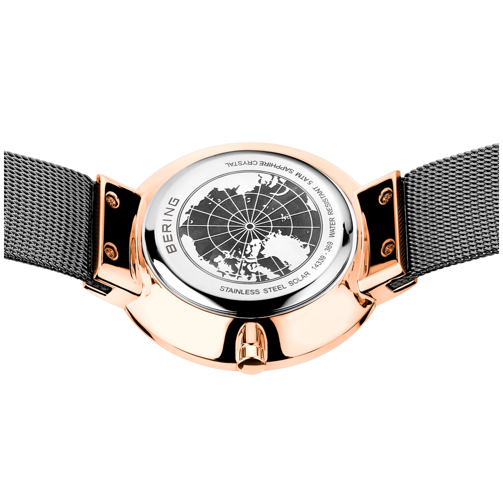 Engraved watch case back with the grey mesh strap extended to either side.