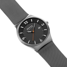 Diagonal overhead view of the dark grey dial with white numerals, dark silver-tone case and grey mesh strap.