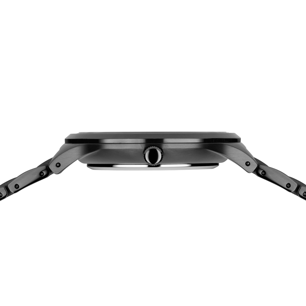 Side profile of the dark silver-tone watch case and crown between the ends of the grey link bracelet.