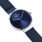Diagonal overhead view of the blue dial, silver-tone case and blue mesh strap.