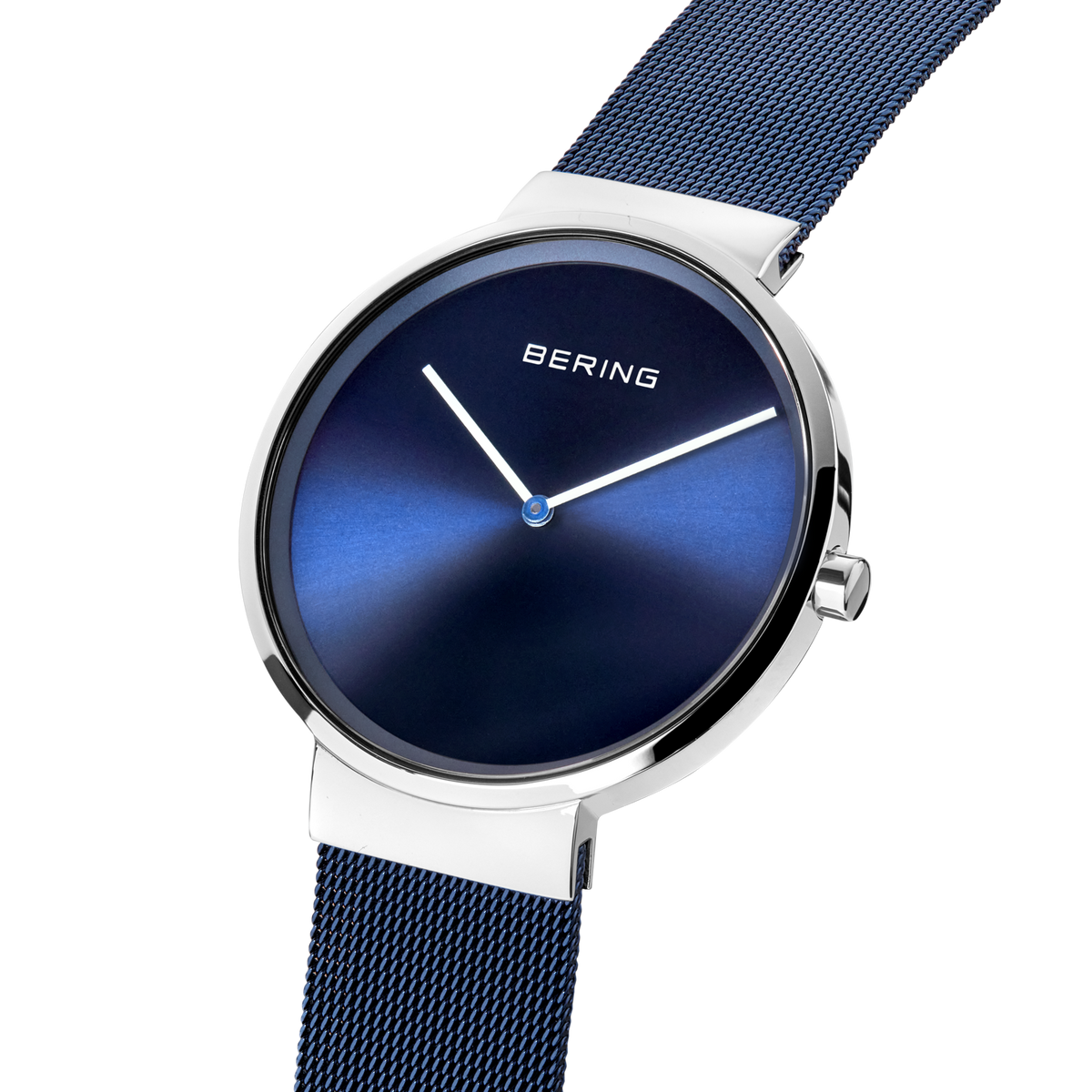 Angled close-up of the blue dial and silver-tone case beside the blue mesh strap.