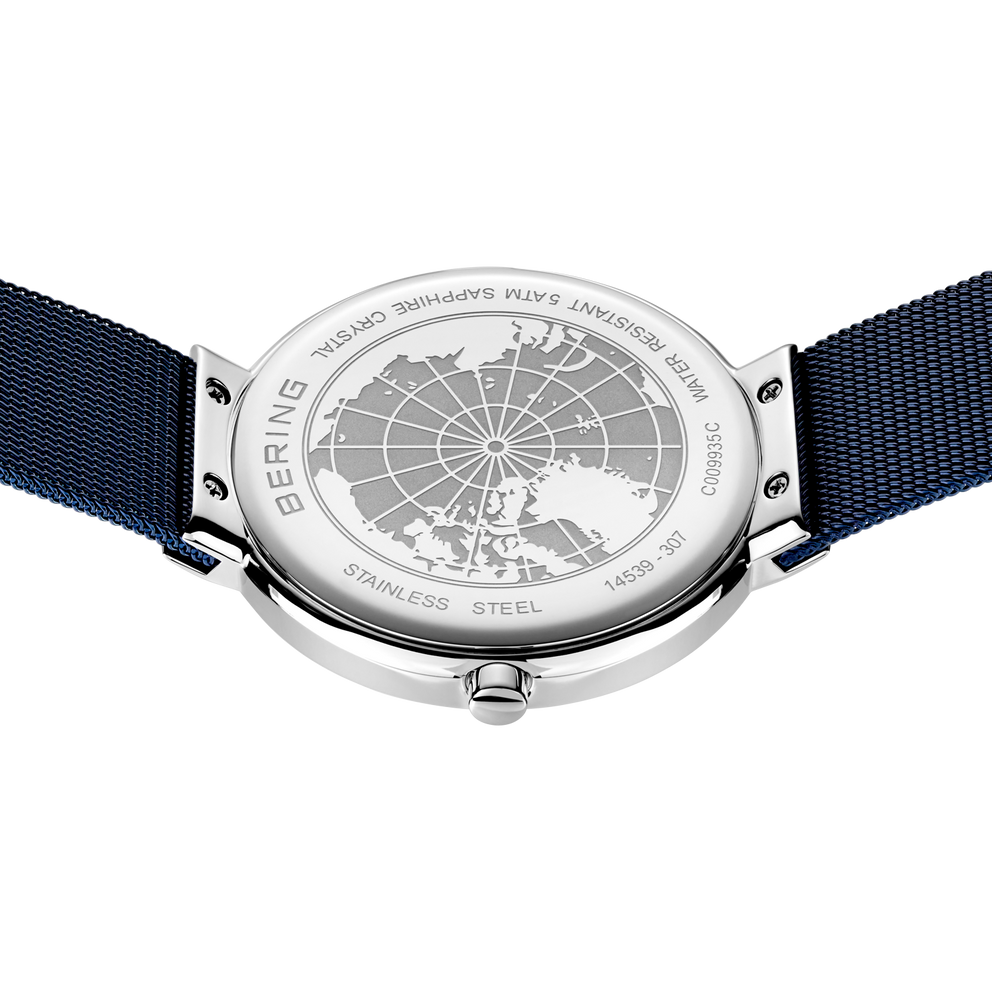 Engraved watch case back with the blue mesh strap extended to either side.