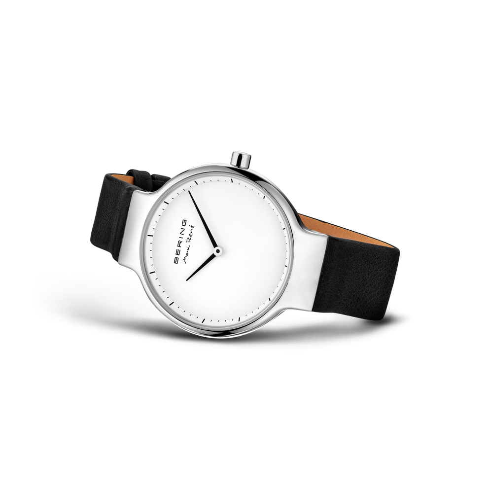 Reloj de esfera blanca apoyado en ángulo, con correa negra lisa extendida.