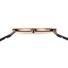 Side profile of the rose-tone watch case and crown between the ends of the black mesh strap.