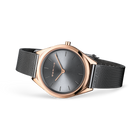 Reloj de esfera gris apoyado en ángulo, con correa de malla gris extendida.