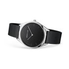 Reloj de esfera negra apoyado en ángulo, con correa de malla negra extendida.