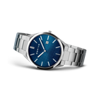 Angled watch view: textured blue dial and silver-tone link bracelet extended.