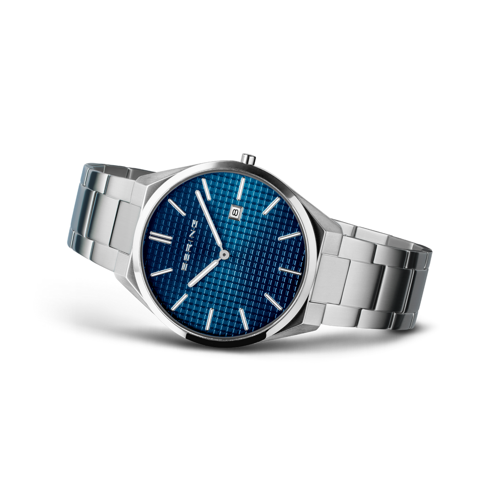 Angled watch view: textured blue dial and silver-tone link bracelet extended.