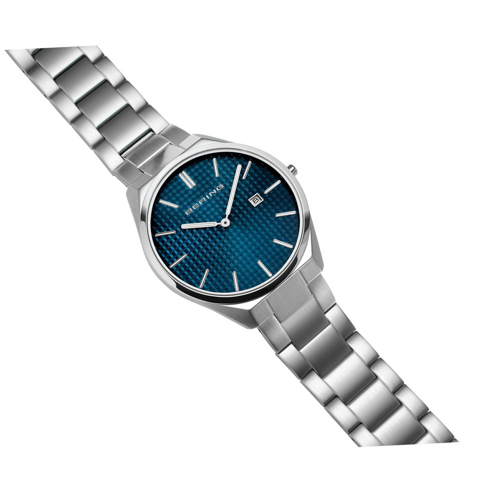 Diagonal overhead view of the textured blue dial, silver-tone case and silver-tone link bracelet.