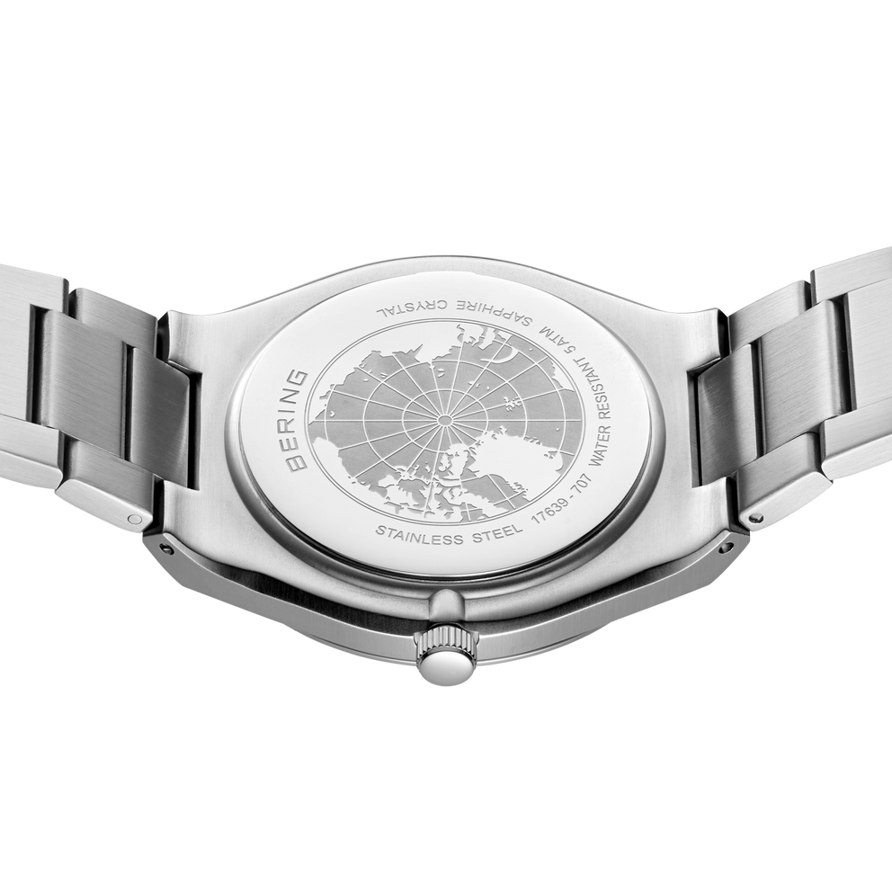 Engraved watch case back with the silver-tone link bracelet extended to either side.