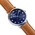 Diagonal overhead view of the blue dial with white numerals, silver-tone case and stitched brown strap.