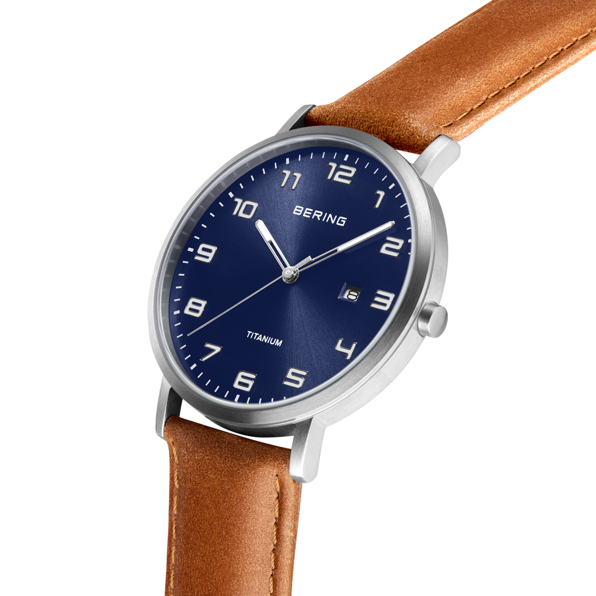 Angled close-up of the blue dial with white numerals and silver-tone case beside the stitched brown strap.