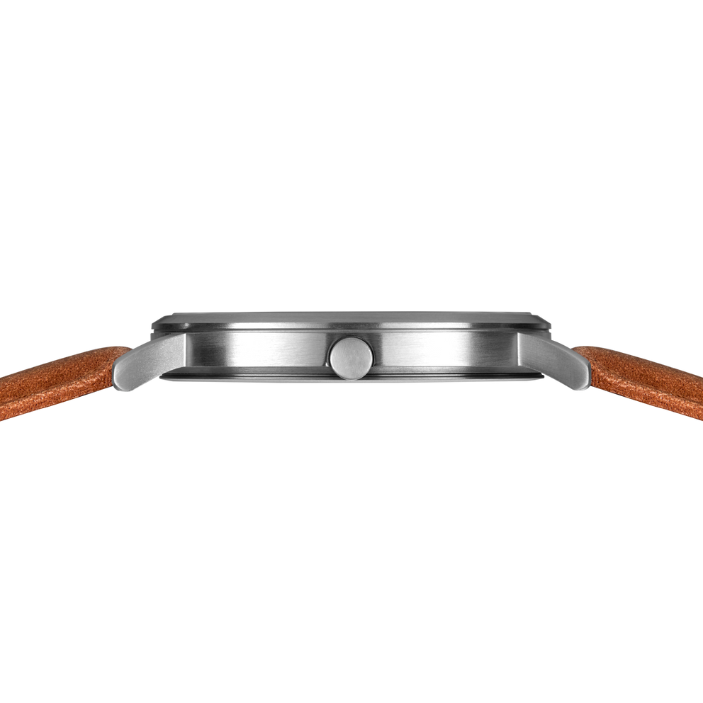Side profile of the silver-tone watch case and crown between the ends of the stitched brown strap.