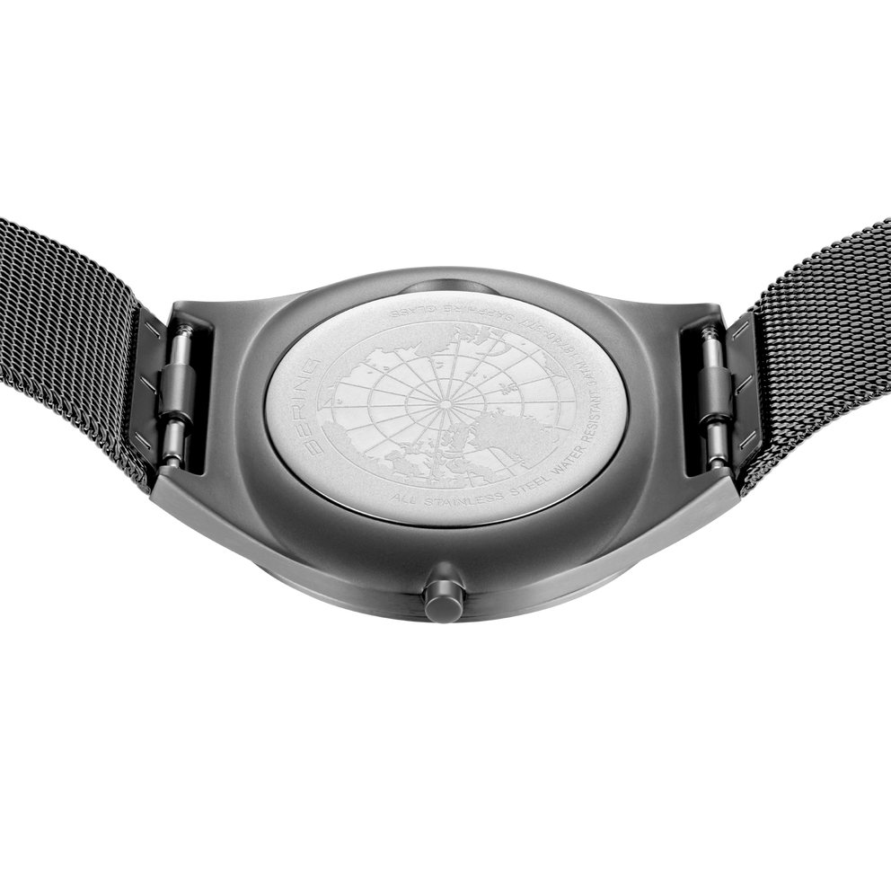 Engraved watch case back with the grey mesh strap extended to either side.