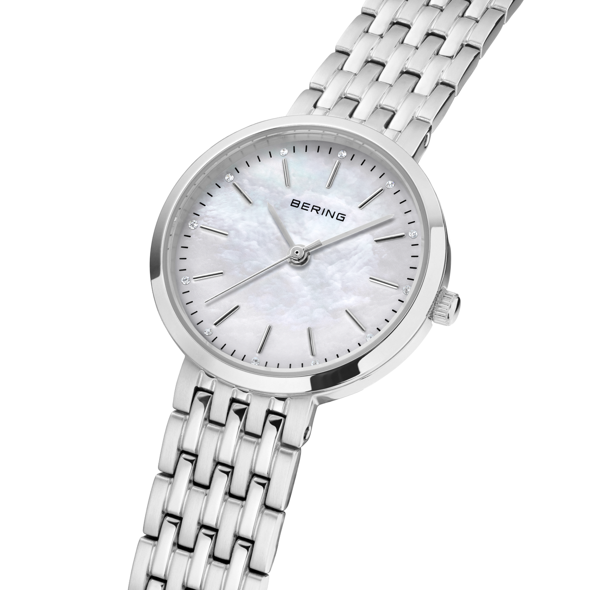 Angled close-up of the pale mottled dial and silver-tone case beside the silver-tone link bracelet.