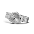 Reloj de esfera gris plateada apoyado en ángulo, con pulsera plateada de eslabones extendida.