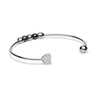 Brazalete abierto plateado girado para mostrar la cara brillante del extremo de corazón.