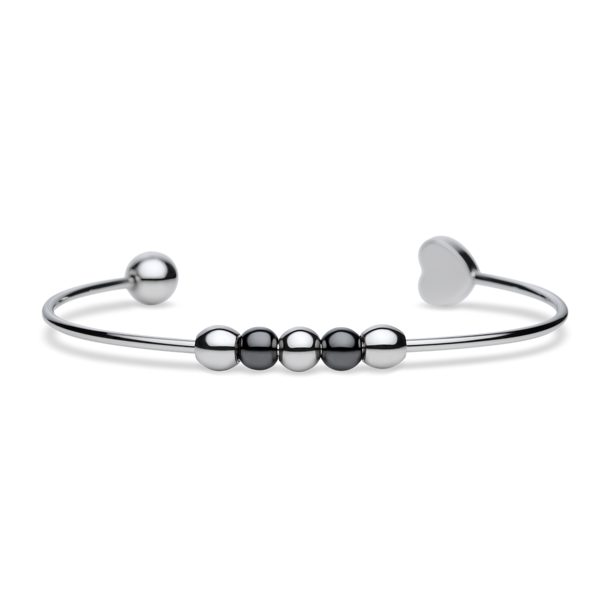 Brazalete abierto plateado con cuentas oscuras pulidas, un extremo redondo y otro de corazón, tumbado.