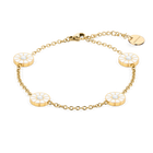 Pulsera de cadena dorada con cuatro detalles redondos abiertos con radios, dispuesta en óvalo.